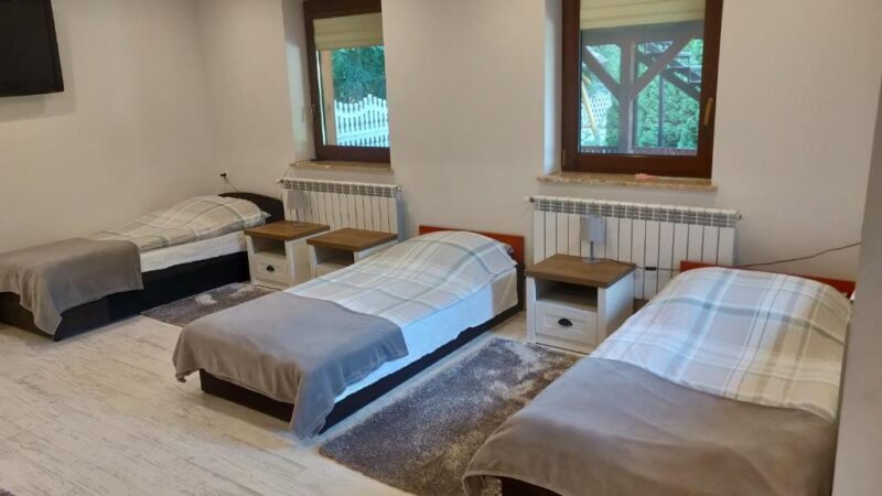 Pokój w agroturystyce nad Bugiem, widać na nim jasny i zadbany pokój z trzema łóżkami.